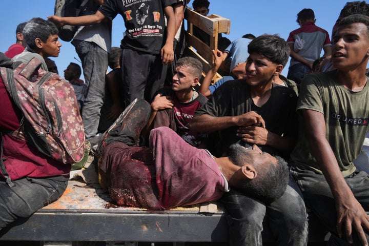 Palestinians, including an injured man, ride on an aid truck returning to Gaza City from the northern Gaza Strip, Saturday, Aug. 23, 2025. (AP Photo/Abdel Kareem Hana)