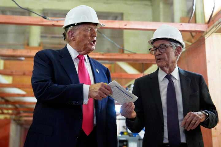 President Donald Trump, left, hands a document of cost figures to Federal Reserve Chairman Jerome Powell during a visit to the Federal Reserve, Thursday, July 24, 2025, in Washington. (AP Photo/Julia Demaree Nikhinson)