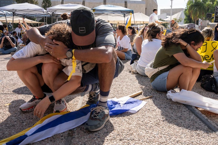 Israelis sit on the ground and cover their heads as a siren warns of incoming missile fire from Yemen, during a protest in Tel Aviv demanding the release of hostages held by Hamas and calling for the Israeli government to reverse its decision to take over Gaza City, on Aug. 17, 2025.