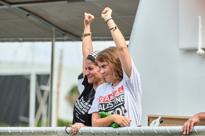 Greta Thunberg (R) raises her fist from a flotilla ship in Barcelona, Spain, on Aug. 31, 2025. Activists from over 40 countries are departing for Gaza as part of the Global Sumud Flotilla (GSF), an effort to break the Israeli blockade and deliver humanitarian aid to Palestinians in the territory.