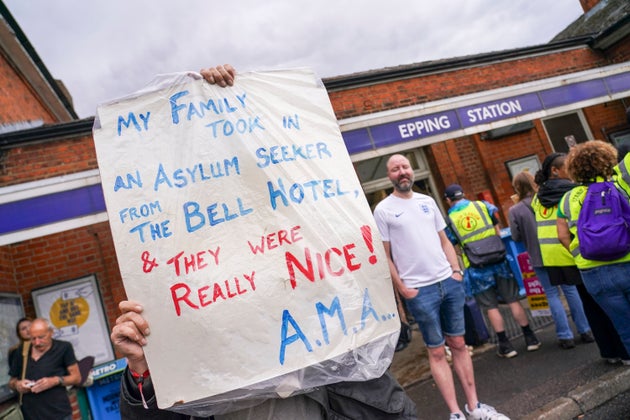A demonstrator holds a placard prior to a march to the Bell Hotel in Epping, near London, Sunday, July 27, 2025.