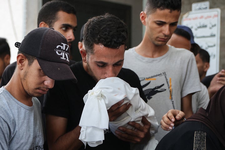 A Palestinian man kisses the shrouded body of a child killed in Israeli strikes on Gaza City, during a funeral procession outside Al-Shifa Hospital on Sept. 4, 2025.