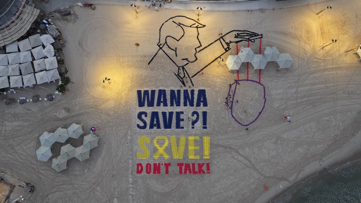 An aerial view of an illustration created by a group of Israeli activists, where U.S. President Donald Trump and Israeli Prime Minister Benjamin Netanyahu are depicted with the words, "Wanna save?! Save!" on the beach near the U.S. Embassy in Tel Aviv, on Sept. 5, 2025.