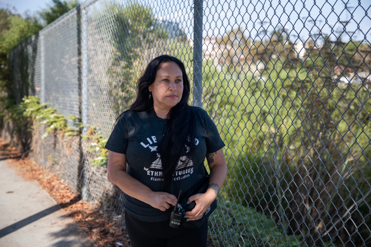 Lupe Carrasco Cardona, a high school ethnic studies teacher in downtown Los Angeles, makes sure students arrive safely at the city bus stop on Sept. 10, 2025. Cardona said she and a group of other educators take up positions around campus to look out for ICE activity and ensure kids make it inside or onto their buses safely.