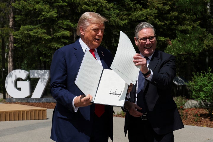 U.S. President Donald Trump, left, and Britain's Prime Minister Keir Starmer hold a signed U.K.-U.S. trade agreement during a meeting at the G7 summit, in Kananaskis, Alberta, on June 16, 2025.