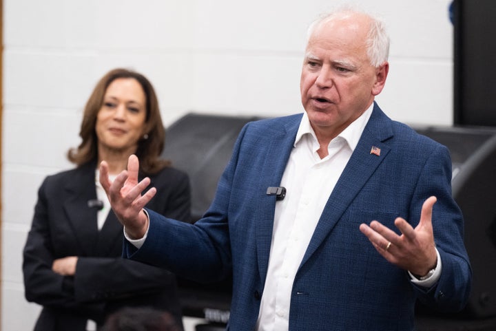 Vice President Kamala Harris listens to her running mate, Governor Tim Walz, speak during a visit with members of the marching band at Liberty County High School in Hinesville, Georgia, on August 28, 2024.