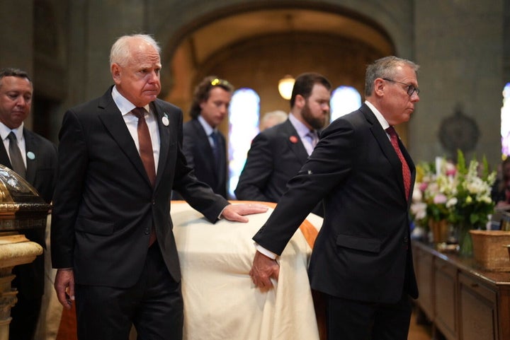 Gov. Tim Walz, left, walks with Melissa Hortman's casket as it is processed through the aisle in the sanctuary at the Basilica of St. Mary during funeral services for Mark and Melissa Hortman in Minneapolis, Minn., on Saturday, June 28, 2025.