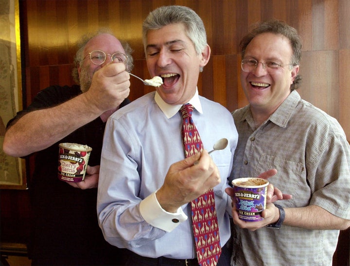Each armed with a pint of their popular Vermont-based ice cream, Ben & Jerry's co-founders Ben Cohen, left, and Jerry Greenfield, right, feed Unilver U.S. CEO Richard Goldstein Monday, May 1, 2000, in Unilver's New York offices.