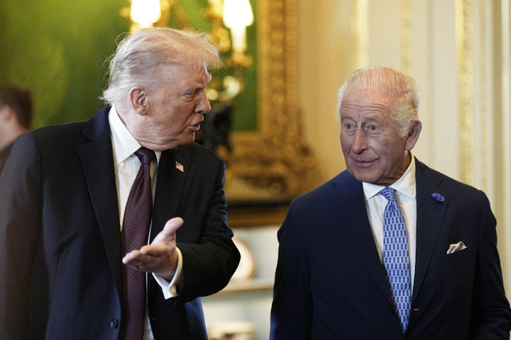 Donald Trump (L) and King Charles III view items on display during a visit to the Royal Collection exhibition, in the Green Drawing Room during the State visit by the U.S. president at Windsor Castle on Sept. 17, 2025 in Windsor, England.