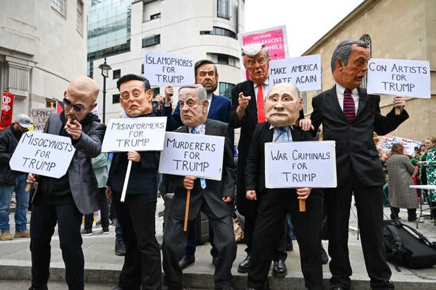 Protesters hold placards during an anti-Trump protest in London, UK, on Wednesday, Sept. 17, 2025. The US and Britain will sign an agreement to make it quicker for companies in both countries to build nuclear power stations when President Donald Trump visits this week, according to the UK government.