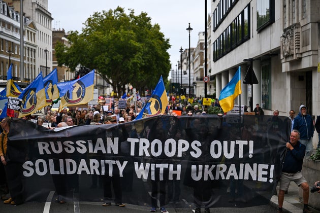 Protesters hold a banner with a slogan which reads