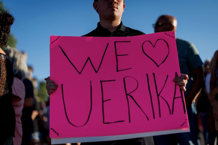  A man holds a sign for Erika Kirk at a memorial for her husband at Phoenix's Turning Point USA headquarters.