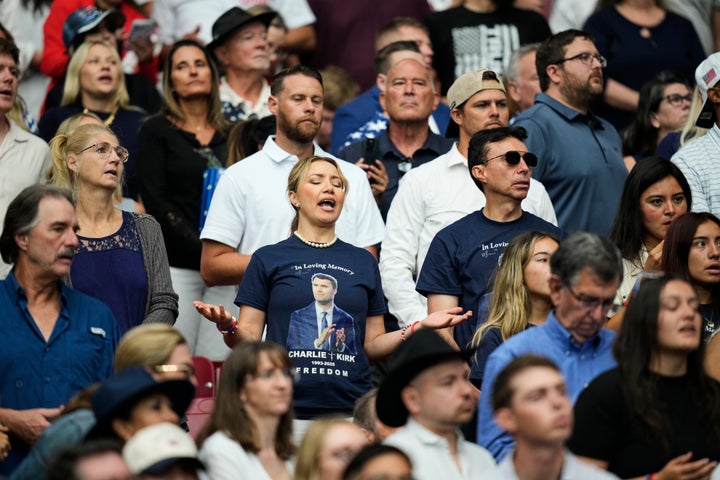 A woman listens during a worship song before the start of a memorial for conservative activist Charlie Kirk, Sunday, Sept. 21, 2025, at State Farm Stadium in Glendale, Ariz. (AP Photo/John Locher)