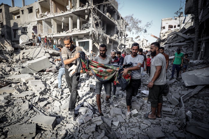 Palestinians pull the body of a child under the rubble following Israel's attacks in the Shati Refugee Camp, west of Gaza City on September 26, 2025. (Photo by Khames Alrefi/Anadolu via Getty Images)