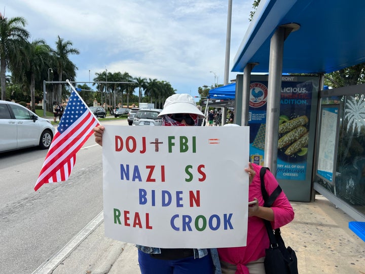 Two Trump supporters in Miami — who did not want to be recognized — hide behind their poster that seemed to imply that President Joe Biden was a Nazi in 2023.
