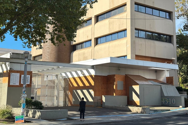 A person stands outside a U.S. Immigration and Customs Enforcement facility on Saturday, Sept. 27, 2025 in Portland, Ore. (AP Photo/Gillian Flaccus)