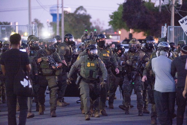Federal immigration agents and Border Patrol Commander Gregory Bovino march outside the ICE detention center in Broadview, Illinois, on Sept. 27. Demonstrators gathered to oppose the Trump administration's immigration crackdown, including 'Operation Midway Blitz,' as clashes escalated with reports of tear gas and pepper balls used to disperse crowds.