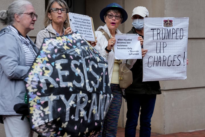 James Comey Pleads Not Responsible Of Mendacity To Congress After Shock Indictment 1 Demonstrators hold signs outside the Alexandria courthouse.