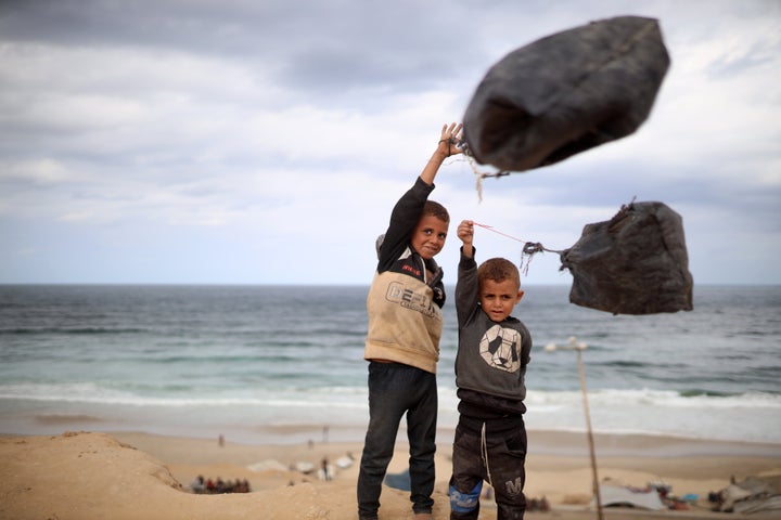 Displaced children pose outside their tents near the Nuseirat camp in Gaza, on Oct. 9, 2025, following news of a new Gaza peace deal.