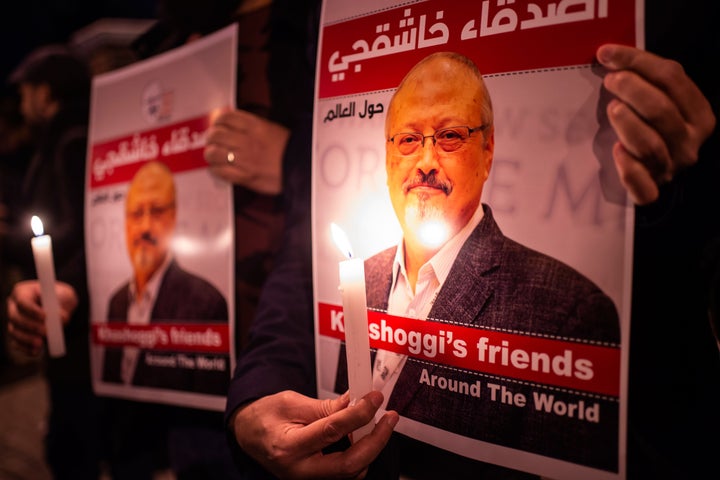 People hold posters picturing Saudi journalist Jamal Khashoggi and light candles during a gathering outside the Saudi Arabia consulate in Istanbul, on Oct. 25, 2018.