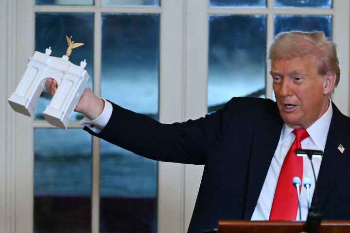 President Donald Trump holds up a model for a proposed 