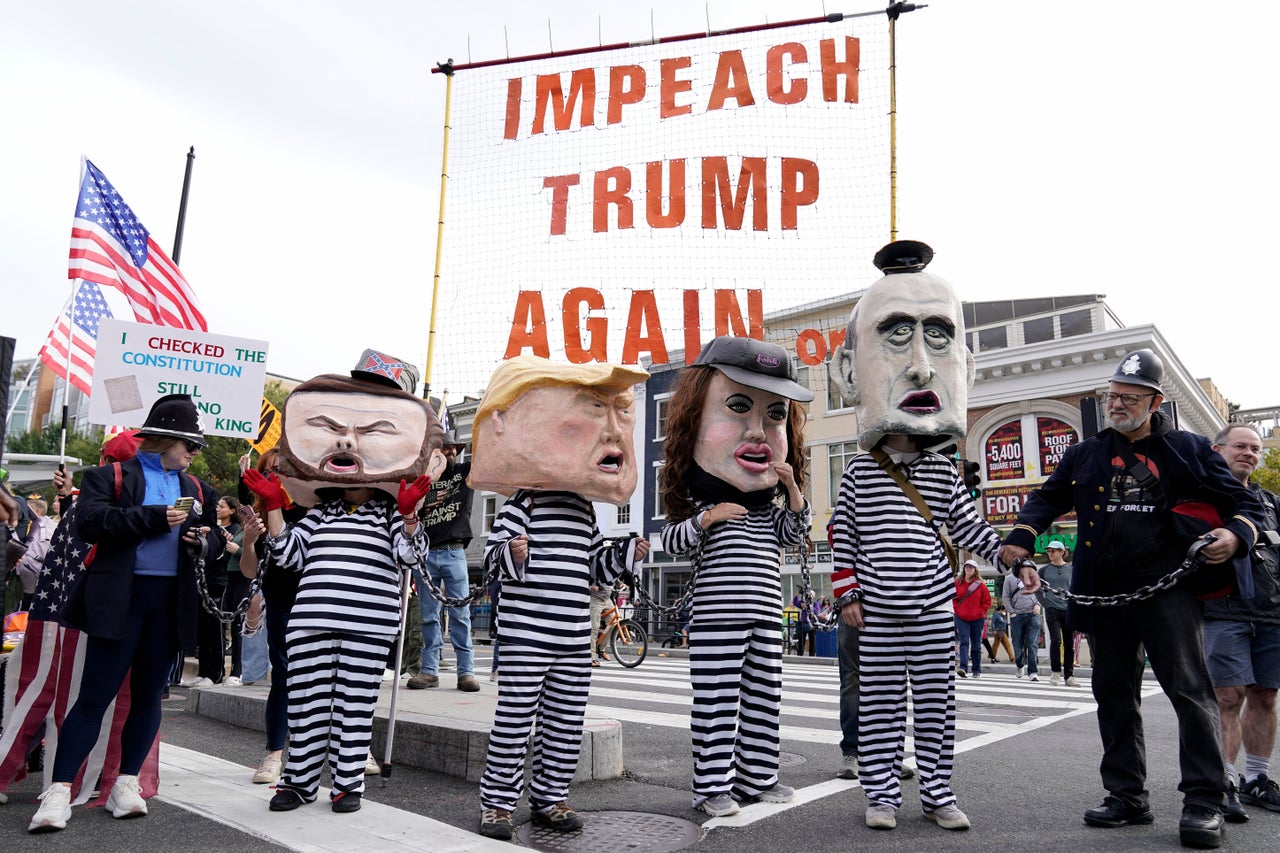 Demonstrators wear costumes depicting Trump and members of his administration in striped prison uniforms in Washington, D.C.