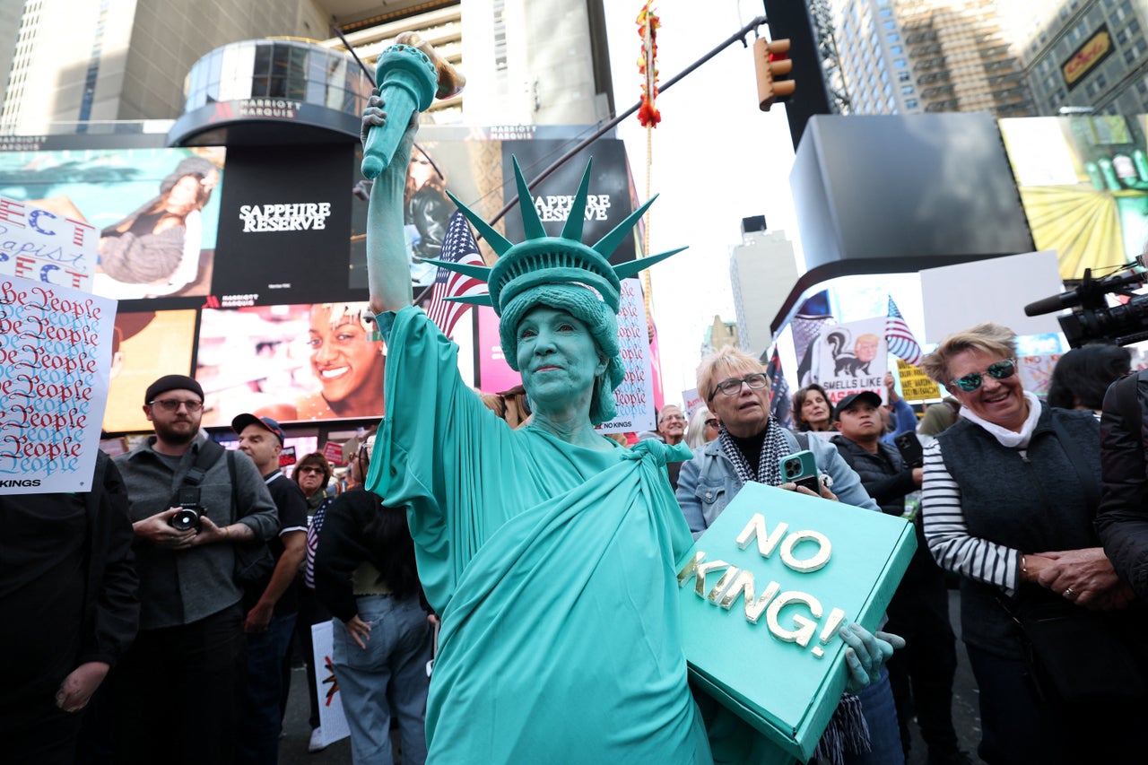 A person dressed as the Statue of Liberty joins a "No Kings" protest in New York City.