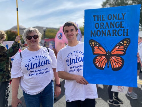 Demonstrators in Washington, D.C., hold a sign that features a monarch butterfly. It reads, "The Only Orange Monarch."