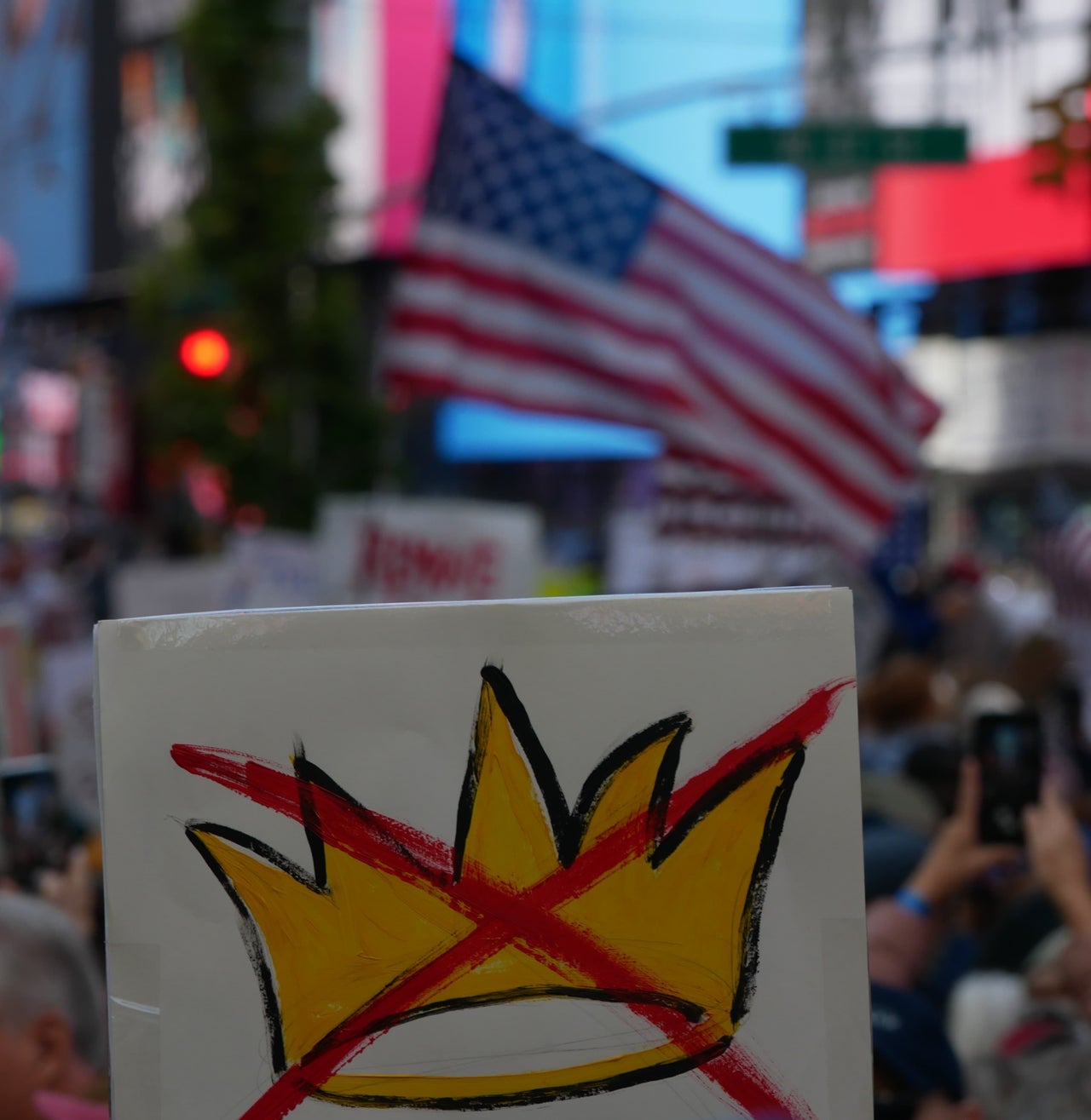 A protestor carries a sign with a crown crossed out. The "No Kings" protest in New York City drew thousands of people Saturday.