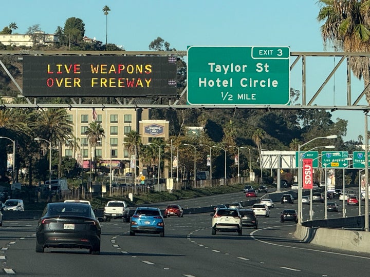 Freeway signs warn drivers on Interstate 8 approaching Interstate 5 of "Live Weapons Over Freeway" in San Diego, California on October 18, 2025. A major US freeway was set to close Saturday during a military live fire exercise that California officials said could endanger drivers. A 17-mile (27-kilometer) coastal stretch of the I-5 interstate between Los Angeles and San Diego will be affected while the Marine Corps fires live rounds over the route to mark its 250th anniversary in an event being attended by Vice President JD Vance. (Photo by Patrick Fallon / AFP) (Photo by PATRICK FALLON/AFP via Getty Images) 