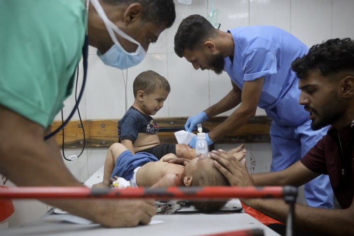 Health care workers treat Palestinian children who were injured in an Israeli airstrike, despite the ceasefire, in Khan Younis, Gaza, on Oct. 19.