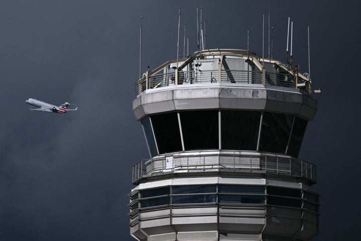 An airplane takes off near the control tower at Reagan National Airport in Arlington, Virginia, on October 8, 2025. (Photo by BRENDAN SMIALOWSKI/AFP via Getty Images)