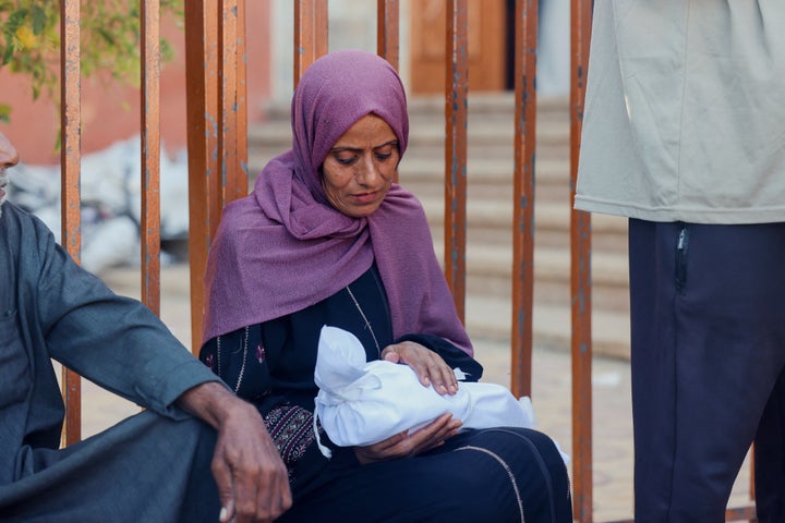 A Palestinian woman holds the body of a baby killed in an Israeli attack in southern Gaza's Khan Younis, on Oct. 20, 2025.