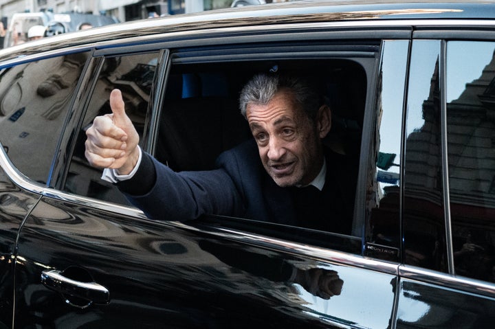 Former French President Nicolas Sarkozy waves to his supporters as he leaves his residence to present himself to La Sante Prison on Oct. 21, 2025.