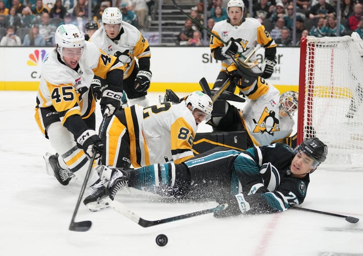 Michael Misa of the San Jose Sharks gets tripped up while attacking the goal against the Pittsburgh Penguins on Saturday.