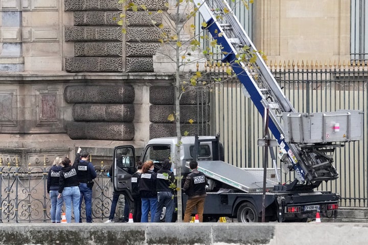 Police officers work by a basket lift used by thieves Sunday, Oct. 19, 2025 at the Louvre museum in Paris. (AP Photo/Thibault Camus)