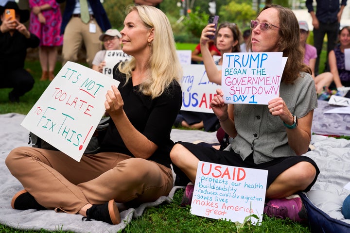 Two women who were laid off from their jobs with the Education Department and a USAID-funded grant respectively, hold signs about the looming government shutdown, on Sept. 30, 2025, on Capitol Hill in Washington, during a rally with former federal employees.