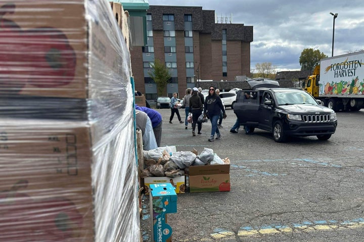 Volunteers drop food in a vehicle's trunk during a Forgotten Harvest distribution event held at Woodside Bible Church, Friday, Oct. 24, 2025, in Pontiac, Mich. (AP Photo/Mike Householder)