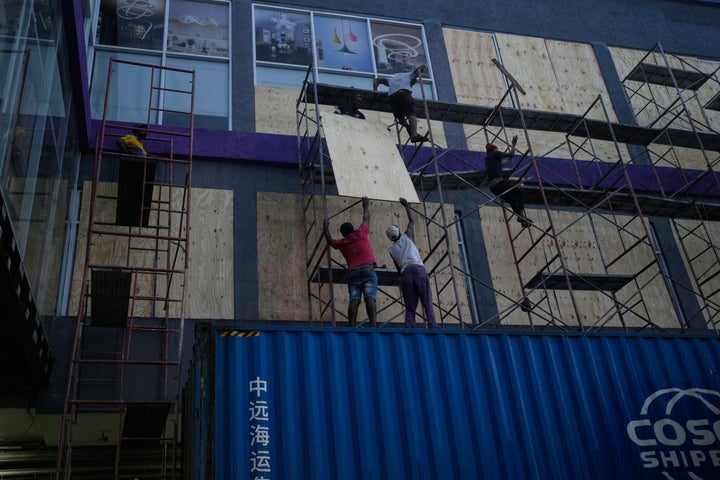 Workers board up shop windows ahead of Hurricane Melissa's forecast arrival in Kingston, Jamaica, on Oct. 26, 2025.