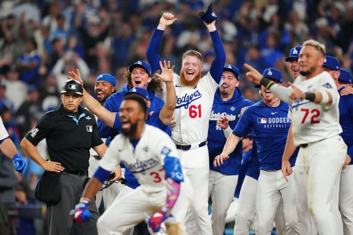 Members of the Los Angeles Dodgers wait for Freddie Freeman (not pictured) to cross home plate after hitting a walk-off solo home run in the 18th inning to win Game Three of the 2025 World Series.