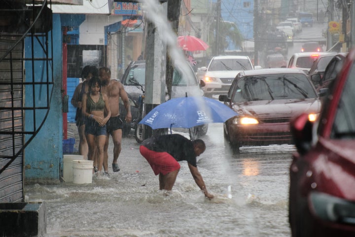 People walk in a street flooded by rains caused by Tropical Storm Melissa in Santo Domingo, Dominican Republic, on Oct. 24, 2025.