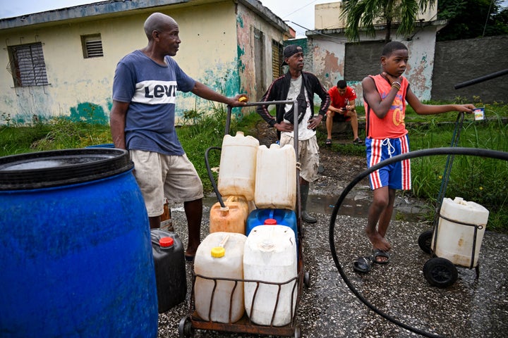 Residents collect water ahead of the arrival of Hurricane Melissa, in Santiago de Cuba, Cuba, on October 28, 2025. (Photo by YAMIL LAGE/AFP via Getty Images)
