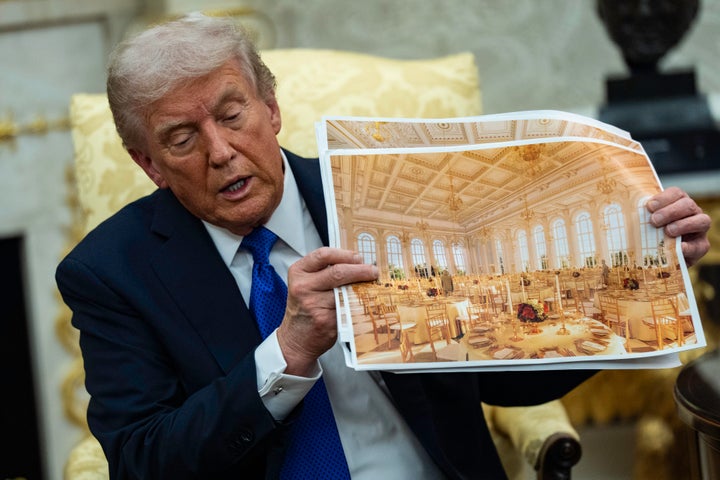 President Donald Trump shows off photos of the new White House ballroom during an Oval Office meeting on Oct. 22.