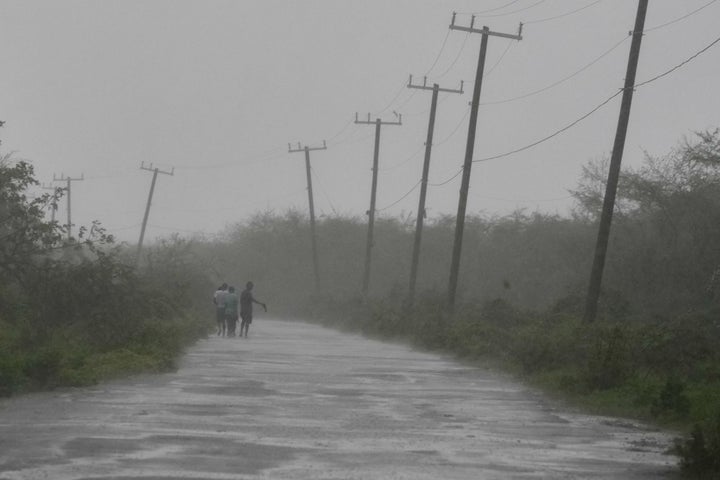 People walk along a road during the passing of Hurricane Melissa in Rocky Point, Jamaica, Tuesday, Oct. 28, 2025. (AP Photo/Matias Delacroix)