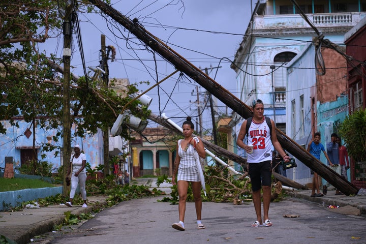 Pedestrians walk in Santiago de Cuba on Oct. 29, 2025, in the aftermath of Hurricane Melissa.