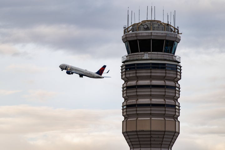 A Delta Airlines plane takes off near the air traffic control tower at Ronald Reagan Washington National Airport (DCA) in Arlington, Virginia, US, on Tuesday, Oct. 28, 2025. (Photographer: Samuel Corum/Bloomberg via Getty Images)