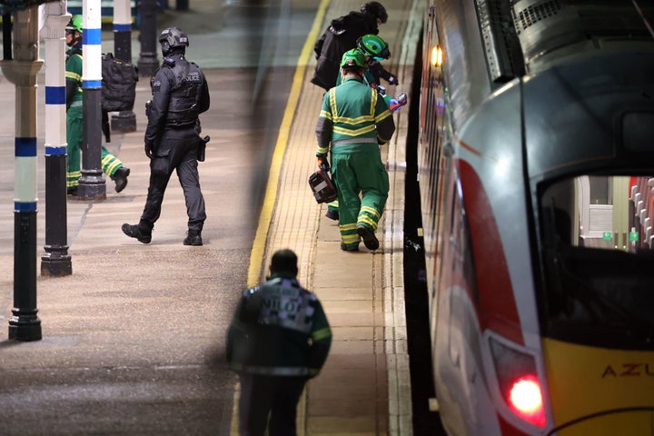 Emergency personnel inspect a train at the Huntingdon, England, train station in Cambridgeshire after people were stabbed Saturday, Nov. 1, 2025. (Chris Radburn/PA via AP)