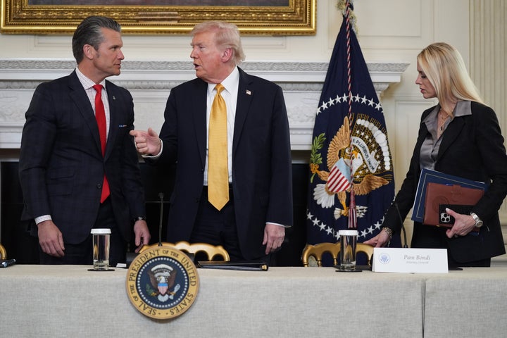 President Donald Trump talks with Defense Secretary Pete Hegseth after a roundtable on criminal cartels in the State Dining Room of the White House on Oct. 23 as Attorney General Pam Bondi watches.