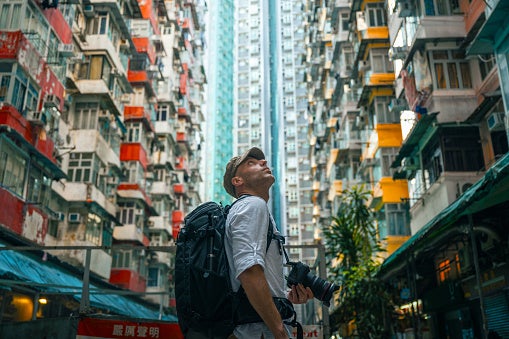 Man looks up at buildings while traveling.