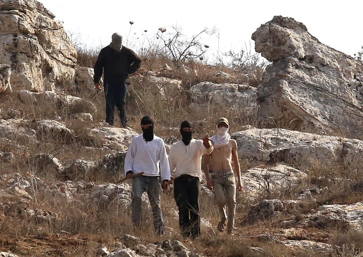 Illegal settlers, covering their faces with masks, attack Palestinian farmers, journalists and foreign activists with sticks and stones in Beita town of Nablus, West Bank on November 08, 2025. (Photo by Nedal Eshtayah/Anadolu via Getty Images)